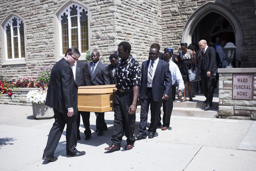 Andrew Loku's casket is carried out of a funeral home.